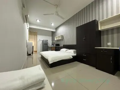 a bedroom with a bed and a sink and a refrigerator at BYSS Homestay Studio in Kampar