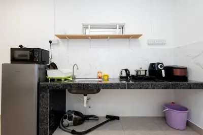 a kitchen with a counter with a sink and a microwave at Casa for 4 - Private Studio Ipoh in Ipoh