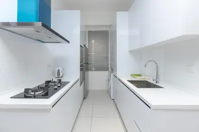 a white kitchen with a stove and a sink at Beacon Executive Suite by MAY in George Town