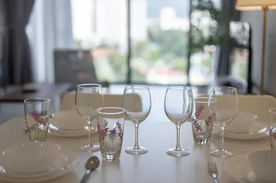 a table with wine glasses and plates on it at Beacon Executive Suite by MAY in George Town