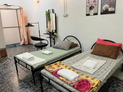 a bedroom with two beds and a table and a chair at Near Aeon Taiping and Taiping Sentral Mall in Kamunting