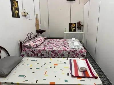 a bedroom with two beds and a table with a bedspread at Near Aeon Taiping and Taiping Sentral Mall in Kamunting