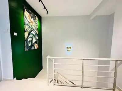 a green wall in a room with a staircase at Rania Pearl Double Storey Family Home, Bertam Penang Homestay in Kepala Batas