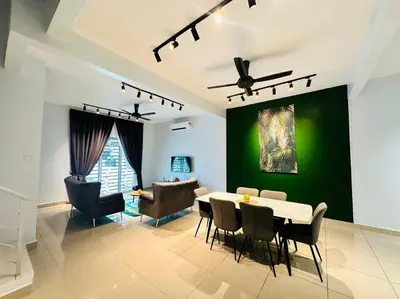 a dining room with a table and a green wall at Rania Pearl Double Storey Family Home, Bertam Penang Homestay in Kepala Batas