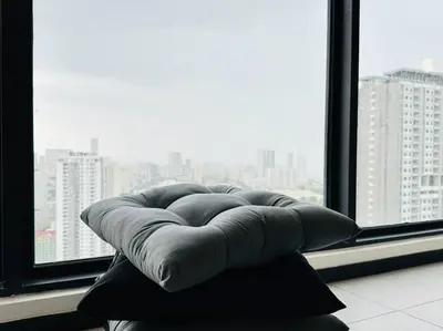a bean bag chair sitting in front of a window at Urban Suites Cozy Home with Netflix and Board games in Jelutong