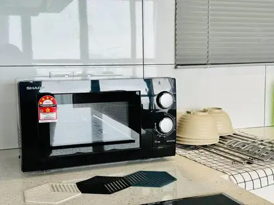 a microwave sitting on a counter in a kitchen at Urban Suites Cozy Home with Netflix and Board games in Jelutong
