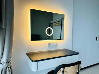 a bathroom with a vanity with a mirror and a chair at Urban Suites Cozy Home with Netflix and Board games in Jelutong