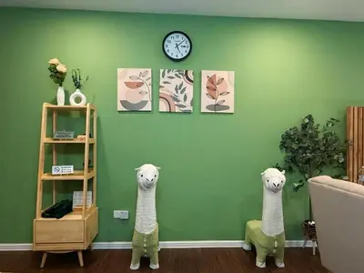 two stuffed animals are on a green wall with a clock at Cameron Palas Homestay in Brinchang