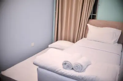 a hotel room with two towels on a bed at Cameron Palas Homestay in Brinchang