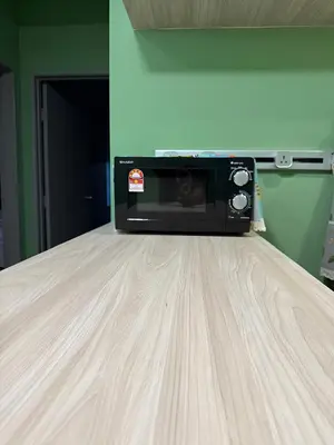 a microwave oven sitting on top of a bed at Cameron Palas Homestay in Brinchang