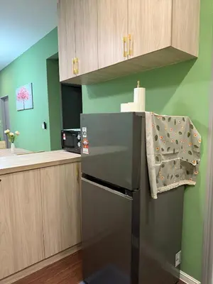 a kitchen with a black refrigerator with a towel on it at Cameron Palas Homestay in Brinchang
