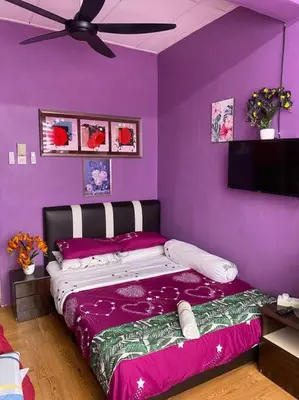 a bedroom with purple walls and a bed with purple sheets at Brite Homestay Nibong Tebal in Kampong Telok