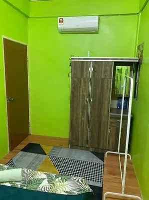 a green room with a shower and a green wall at Brite Homestay Nibong Tebal in Kampong Telok