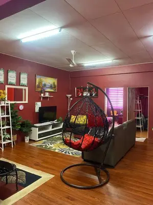 a living room with a bird cage on the floor at Brite Homestay Nibong Tebal in Kampong Telok