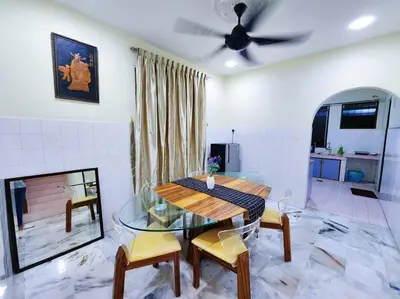 a dining room with a glass table and chairs at Pengkalan 42 Double-Storey Homestay in Kampong Pinji