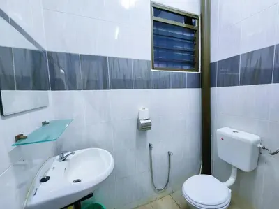 a bathroom with a white toilet and a sink at Pengkalan 42 Double-Storey Homestay in Kampong Pinji