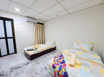 a bedroom with two beds and a window at Pengkalan 42 Double-Storey Homestay in Kampong Pinji
