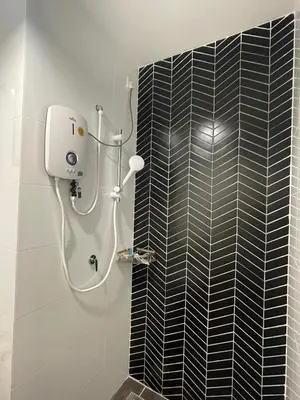 a shower in a bathroom with a black tile wall at The Horizon Ipoh 3BR ORCHID - by Goswell in Ipoh