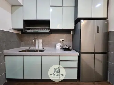 a kitchen with white cabinets and a stainless steel refrigerator at The Cove Ipoh - Blissful Abodes in Tambun