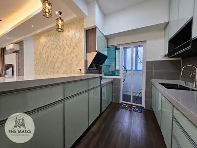 a kitchen with green cabinets and a wooden floor at The Cove Ipoh - Blissful Abodes in Tambun