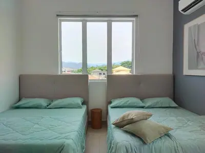 two beds in a room with a window at Tints of Green Pool Bungalow-6 Bedroom-Karaoke-BBQ in Sultan Azlan Shah Airport
