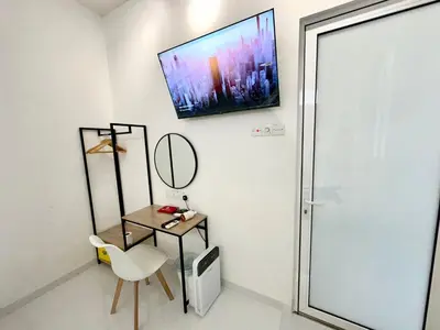 a room with a tv on the wall and a chair at Stylish Cozy Landed Jelutong 3BR 2B 4CP-10pax by 3C in Jelutong