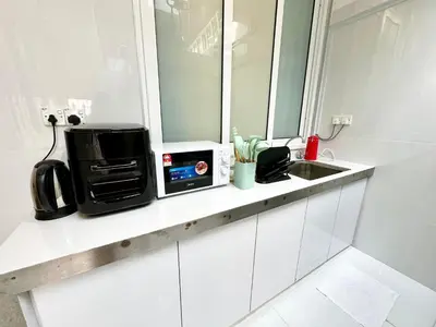 a kitchen counter with a microwave and a sink at Stylish Cozy Landed Jelutong 3BR 2B 4CP-10pax by 3C in Jelutong