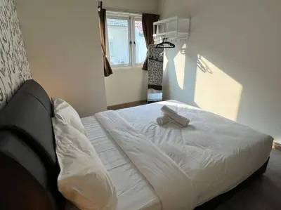 a white bed in a room with a window at Karpal Singh Drive Seaside Georgetown 4BR-15pax by 3C in George Town