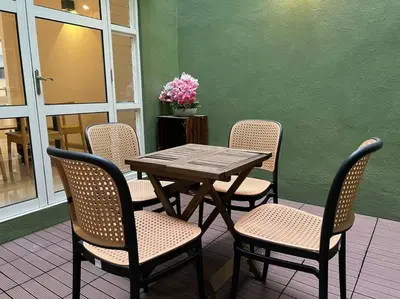 a wooden table and chairs with a table and flowers at Karpal Singh Drive Seaside Georgetown 4BR-15pax by 3C in George Town