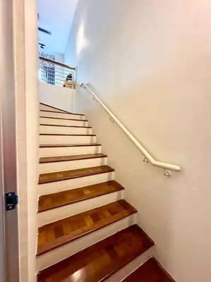 a staircase with wooden steps and a metal hand rail at Karpal Singh Drive Seaside Georgetown 4BR-15pax by 3C in George Town