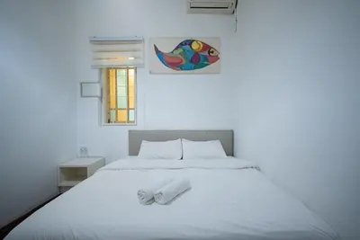 a white bed with two white towels on it at Moustachz Hauze , Georgetown in George Town
