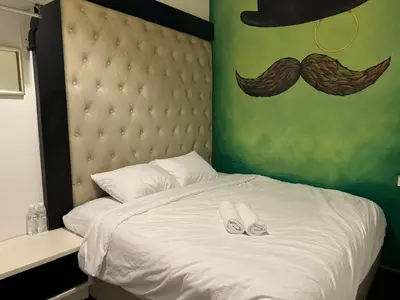 a bed with two pairs of slippers on top of it at Moustachz Hauze , Georgetown in George Town