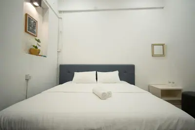 a white bed with a blue headboard in a room at Moustachz Hauze , Georgetown in George Town