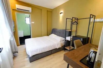 a bedroom with a bed and a shelf in it at Robin Hotel in Ipoh
