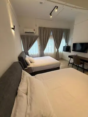 a hotel room with two beds and a television at Robin Hotel in Ipoh