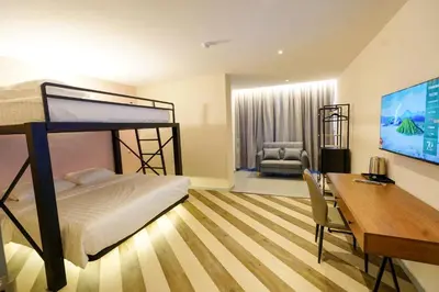 a bedroom with a bunk bed and a desk with a computer at Robin Hotel in Ipoh