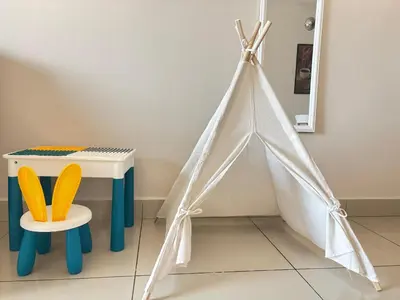 a white play tent next to a table and a chair at Ipoh Town Majestic Suites by IWH Suites in Ipoh