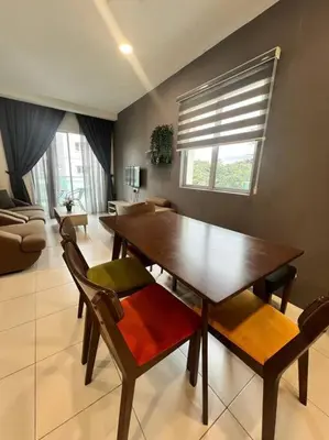 a living room with a wooden table and chairs at LIly Brava 7 in Tanah Rata