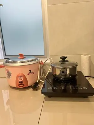 a slow cooker and a pot on a stove at LIly Brava 7 in Tanah Rata