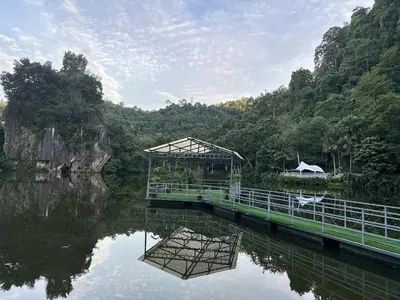 a bridge over a body of water with trees at Ipoh lakeside Suite Ipoh 4pax in Ipoh