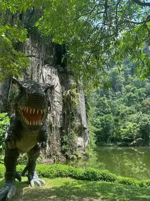 a dinosaur statue standing next to a body of water at Ipoh lakeside Suite Ipoh 4pax in Ipoh