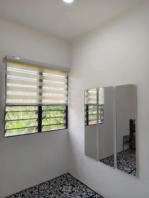 a white room with a mirror and a window at Bougainvillea Garden KKB in Kuala Kubu Baharu