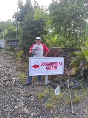 a man is standing next to a sign at Bougainvillea Garden KKB in Kuala Kubu Baharu
