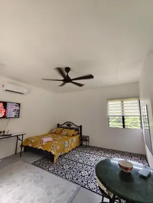 a bedroom with a bed and a ceiling fan at Bougainvillea Garden KKB in Kuala Kubu Baharu