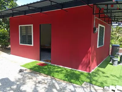 a red house with a green lawn in front of it at Bougainvillea Garden KKB in Kuala Kubu Baharu