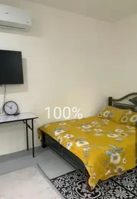 a bedroom with a yellow bed and a tv at Renovate on progress in Kuala Kubu Baharu
