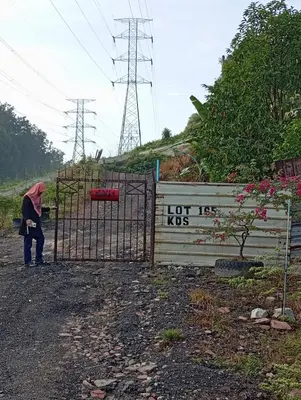 a person standing behind a gate with a sign on it at Renovate on progress in Kuala Kubu Baharu