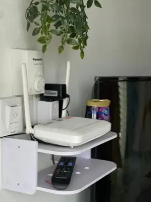 a white phone on a shelf with a remote control at Rumah Kita HStay BM view Self check in 2Room in Kubang Semang