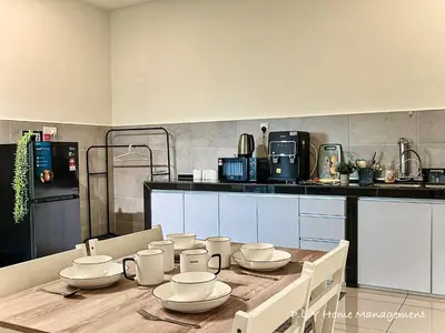 a kitchen with a wooden table with white dishes on it at Kampung Paloh Residence Ipoh with 2 Parking & Free Netflix in Ipoh