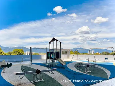 a playground with two swings and a slide at Kampung Paloh Residence Ipoh with 2 Parking & Free Netflix in Ipoh